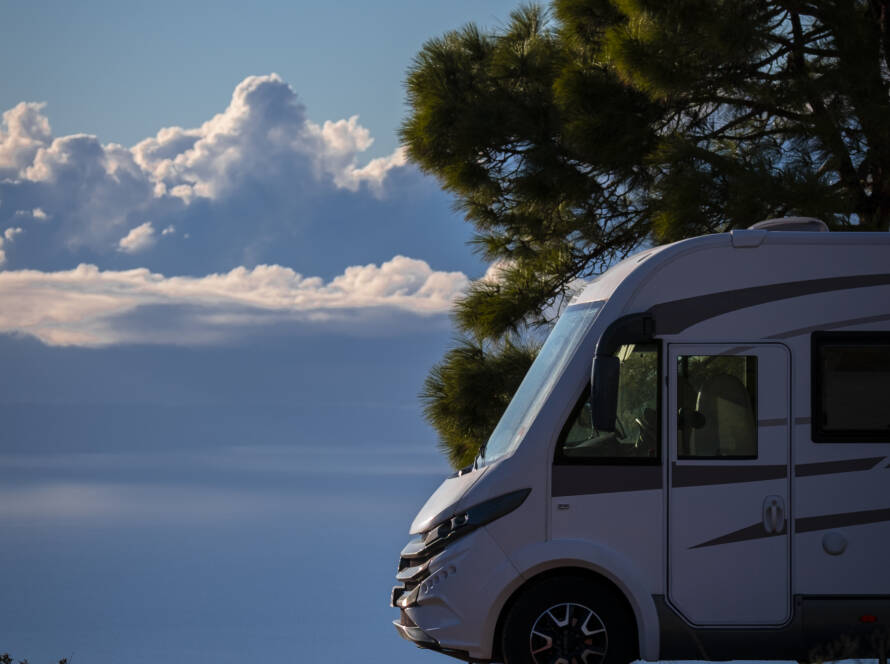 Moderna y elegante autocaravana acogedora estacionada fuera de la carretera con cielo azul
