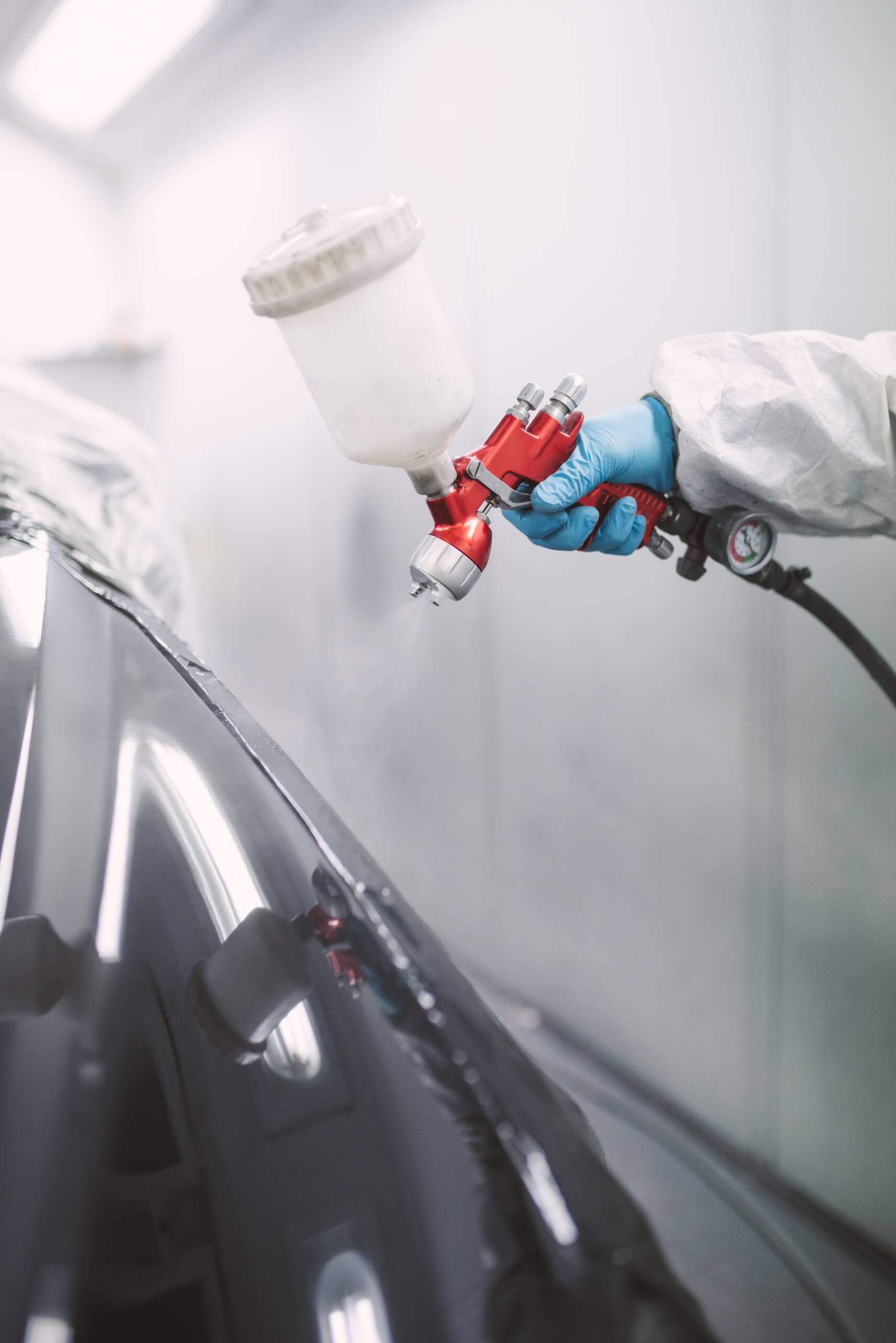 Pintor de automóviles pintando un coche